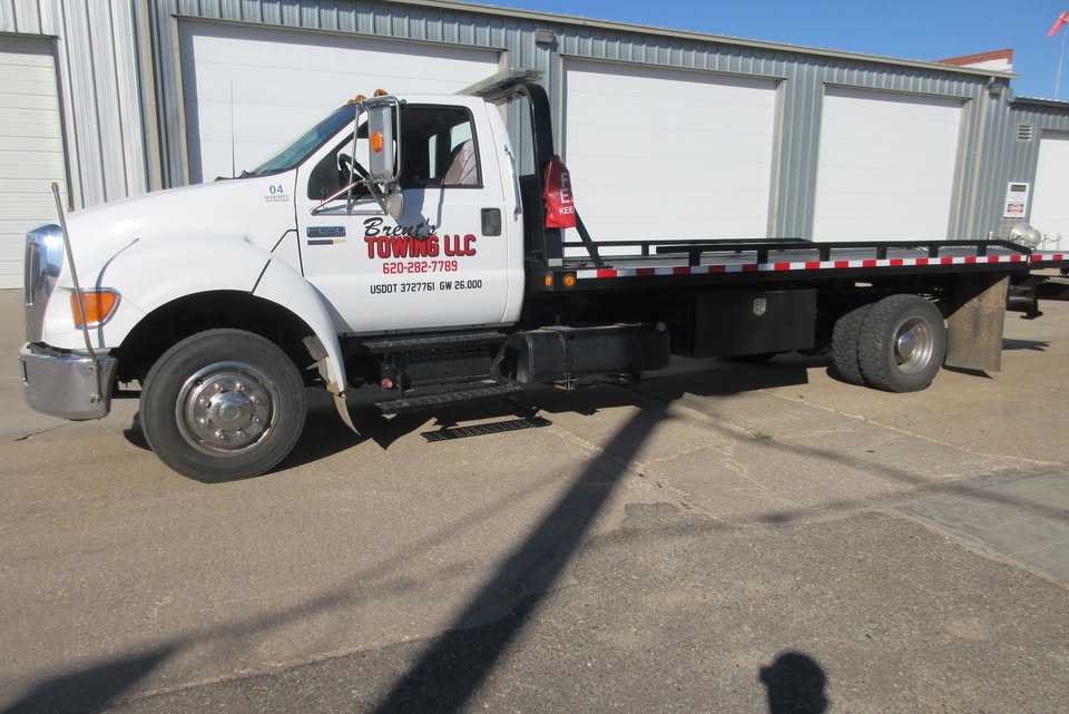 Brent's Towing LLC flatbed tow truck parked outside the shop in Great Bend, Kansas
